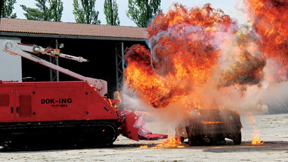 Robot autónomo DOK-ING MVF-5 interviniendo en un incendio mediante sistema de extinción remoto en un entorno de emergencia.